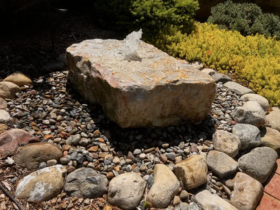 Boulder bubbler water feature in river rock