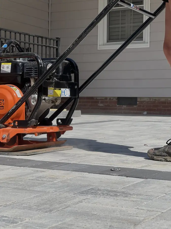 Plate compactor setting a new paver patio