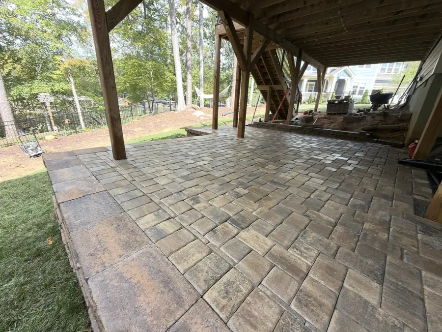 Paver patio beneath a deck by the water