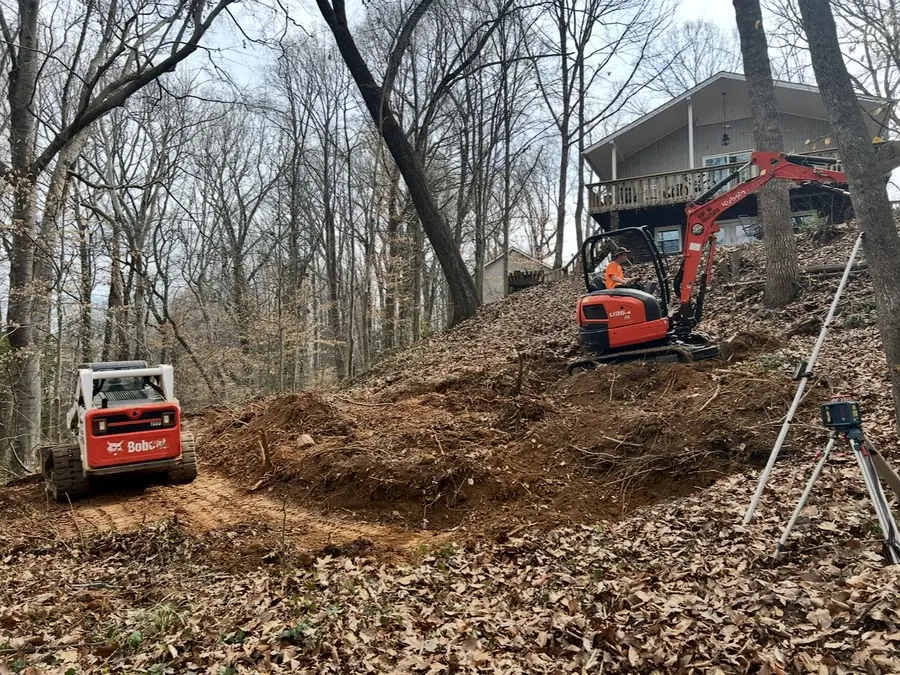 Mini excavator cutting a wall bench into a slope